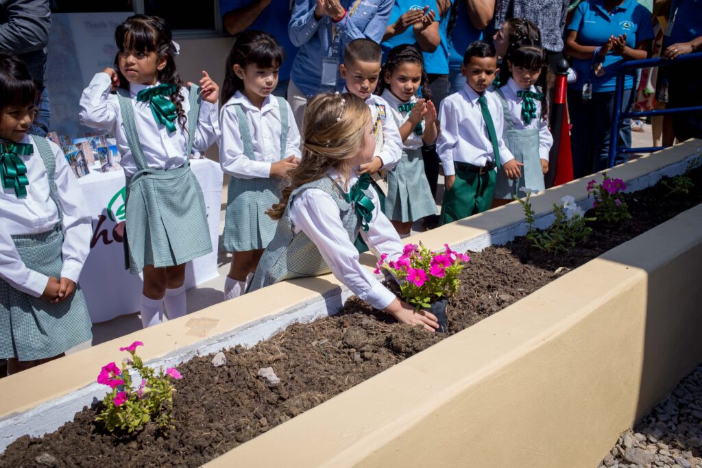 school children plant a flower 