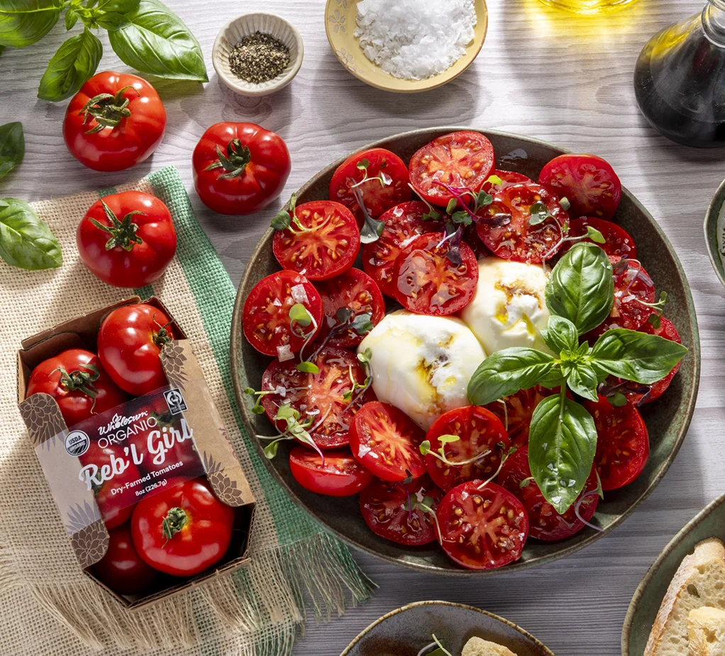 Reb'l Girl tomatoes in packaging and on a plate with cheese and basil